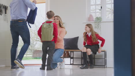 parents helping children in uniform to get ready to leave home for school