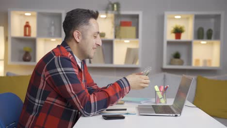 Man-counting-money-at-laptop.