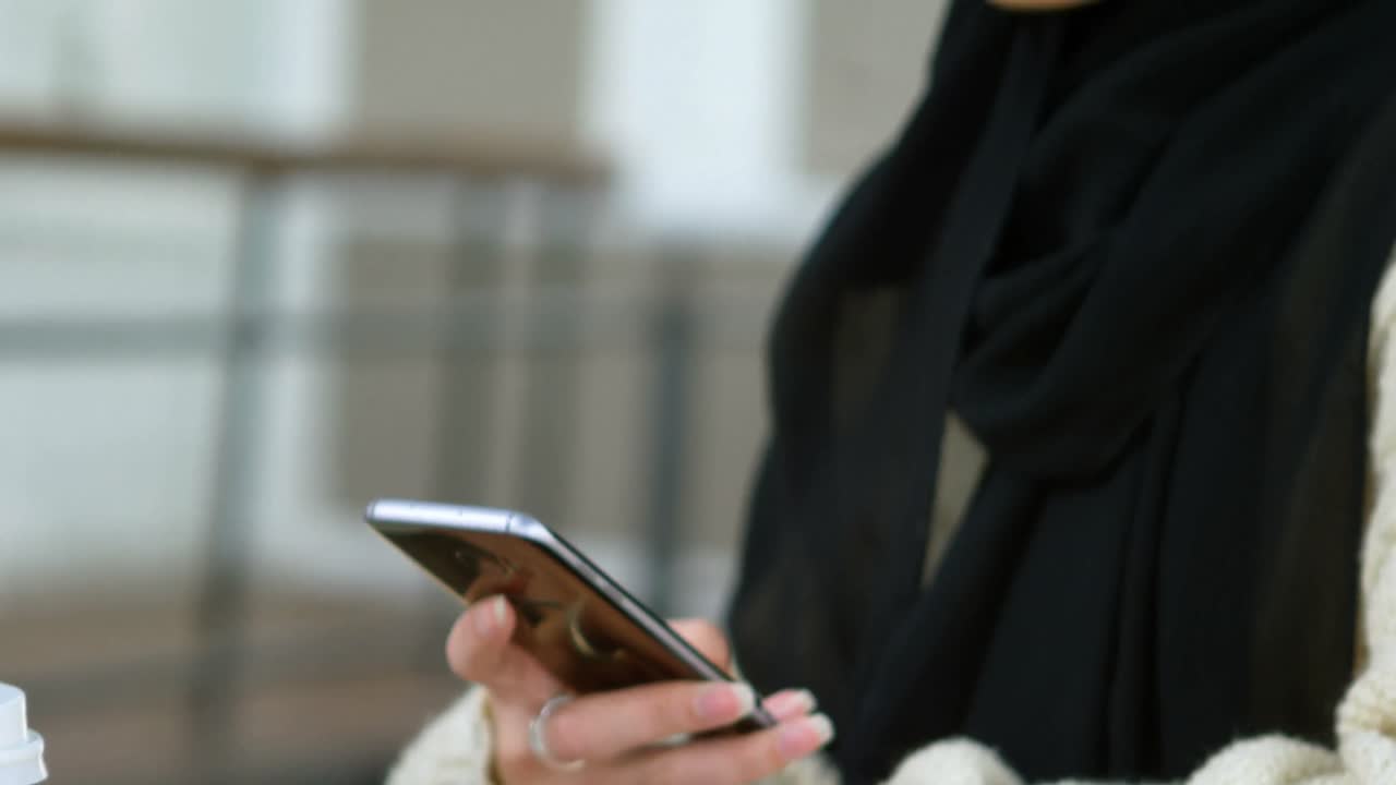 Woman in hijab using mobile phone 4k