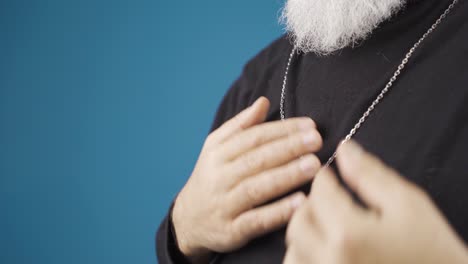 el hombre cristiano lleva el collar de la cruz alrededor de su cuello, lo que significa que cree en jesucristo. dios te bendiga.