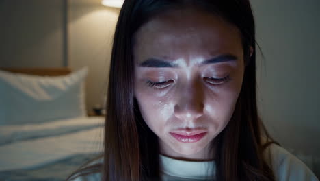 mujer mirando el teléfono en la cama por la noche
