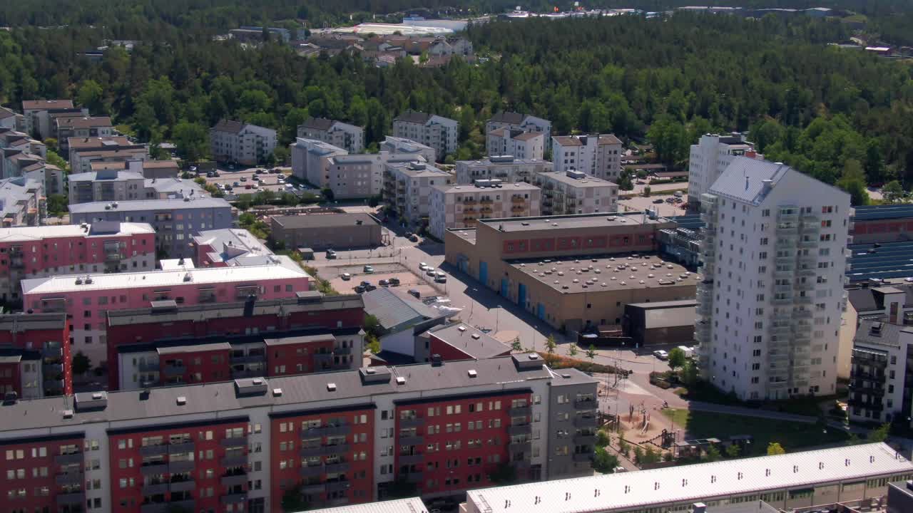 Panoramic aerial of high-rise and low-rise apartments nestled among lush greenery with distant forest in Gustavsberg. Perfect for modern suburban lifestyle visuals