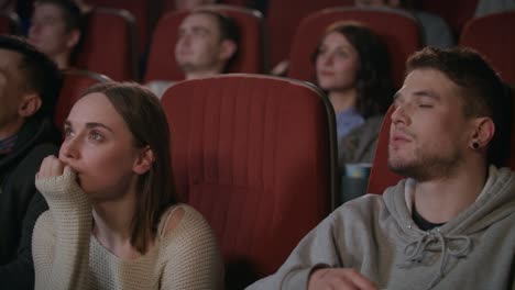 Man-embracing-woman-in-cinema-theater.-Romantic-date-concept