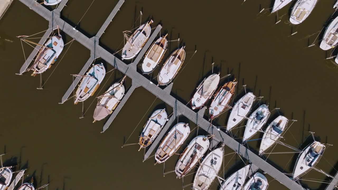 Clockwise spiral aerial zoom out from zenithal view over residential area and lake in Heeg, Netherlands
