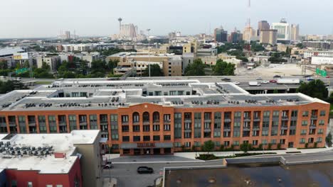 órbita-Aérea-Del-Distrito-De-La-Perla-De-San-Antonio-Del-Centro-De-La-Ciudad,-Panorámica-A-La-Izquierda-Mirando-El-Complejo-De-Apartamentos-Y-Los-Viajeros-De-La-Autopista-Cerca-Del-Paseo-Del-Río-En-4k