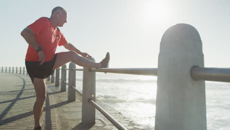 Senior-man-stretching-his-legs-on-the-promenade