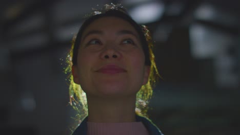 close up of woman visiting and interacting with immersive art exhibition backlit by light from projector 6