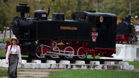 Niña-Rumana-Camina-En-El-Museo-De-Locomotoras-De-Vapor-Al-Aire-Libre-En-Resita,-Rumania-2