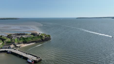 barco que pasa por el fuerte de duncan con la salida del estuario de waterford en el mar celta en el fondo en la mañana de verano