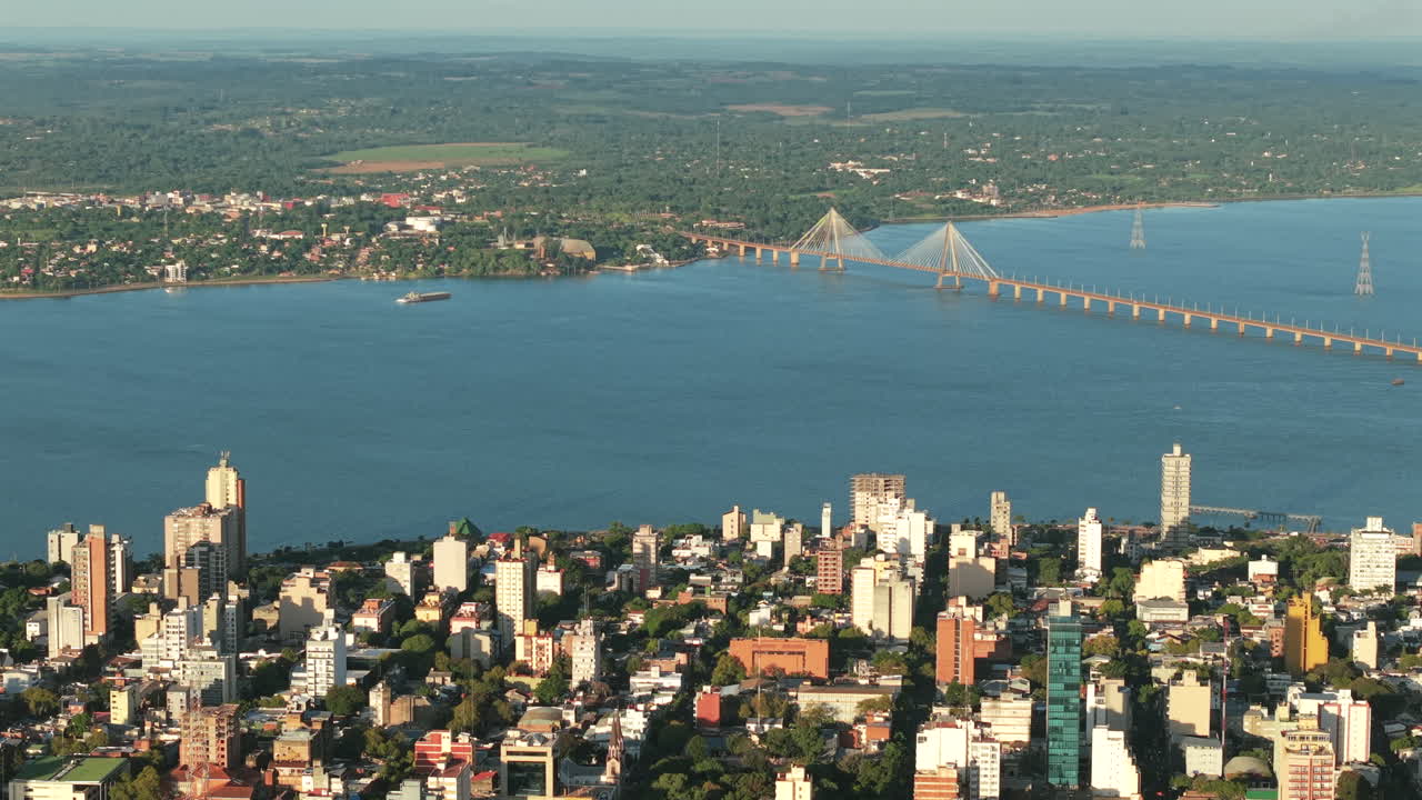 Aerial view of the metropolitan waterside part of Posadas city and International bridge at sunset, Misiones, Argentina.