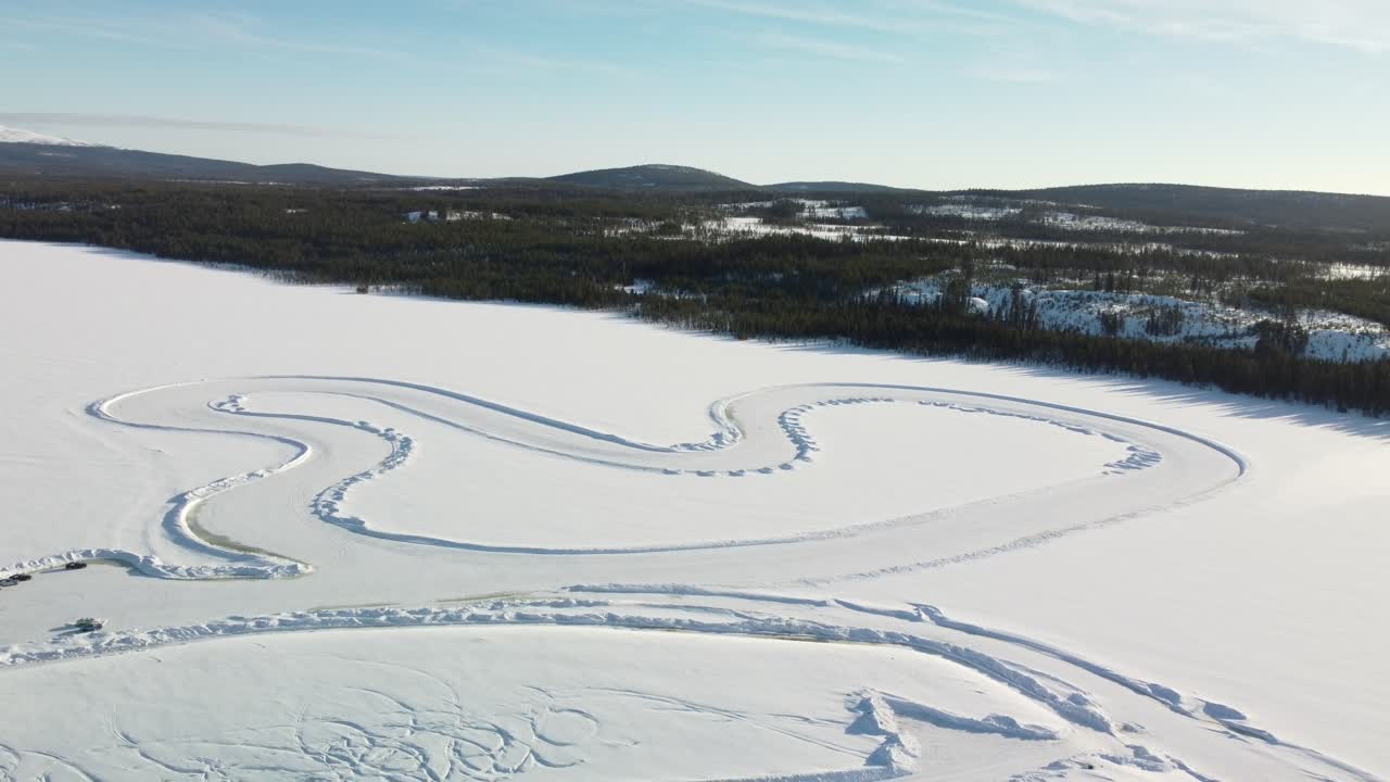 Hele racerbane på en frossen sø i Finland under den gyldne time – Luftfoto af vinterlandskab, orbit-optagelse fra stor højde