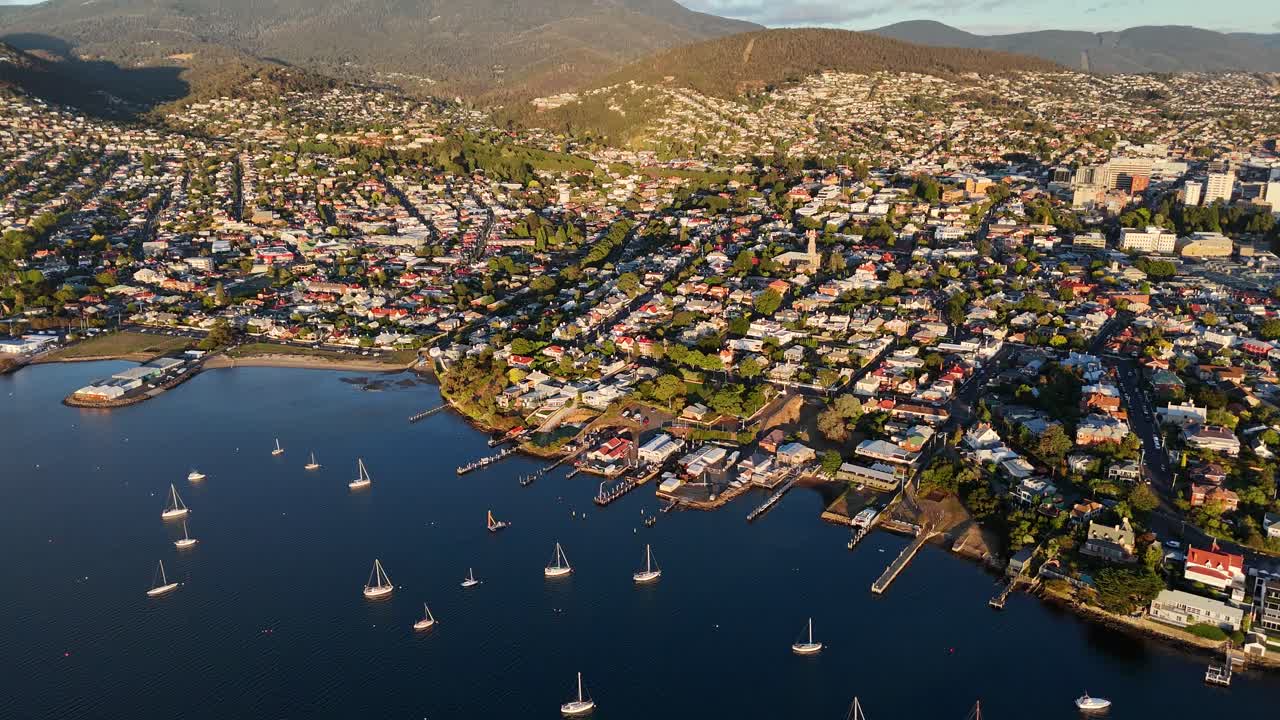 Moored boats near coastal homes of Hobart city in Tasmania, Australia, drone shot