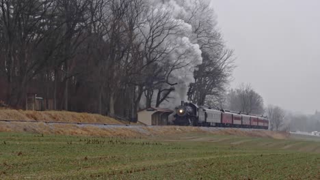 Un-Tren-De-Pasajeros-De-Vapor-Que-Se-Acerca-Con-La-Cabeza-Llena-De-Vapor-En-Un-Día-Lluvioso-De-Invierno