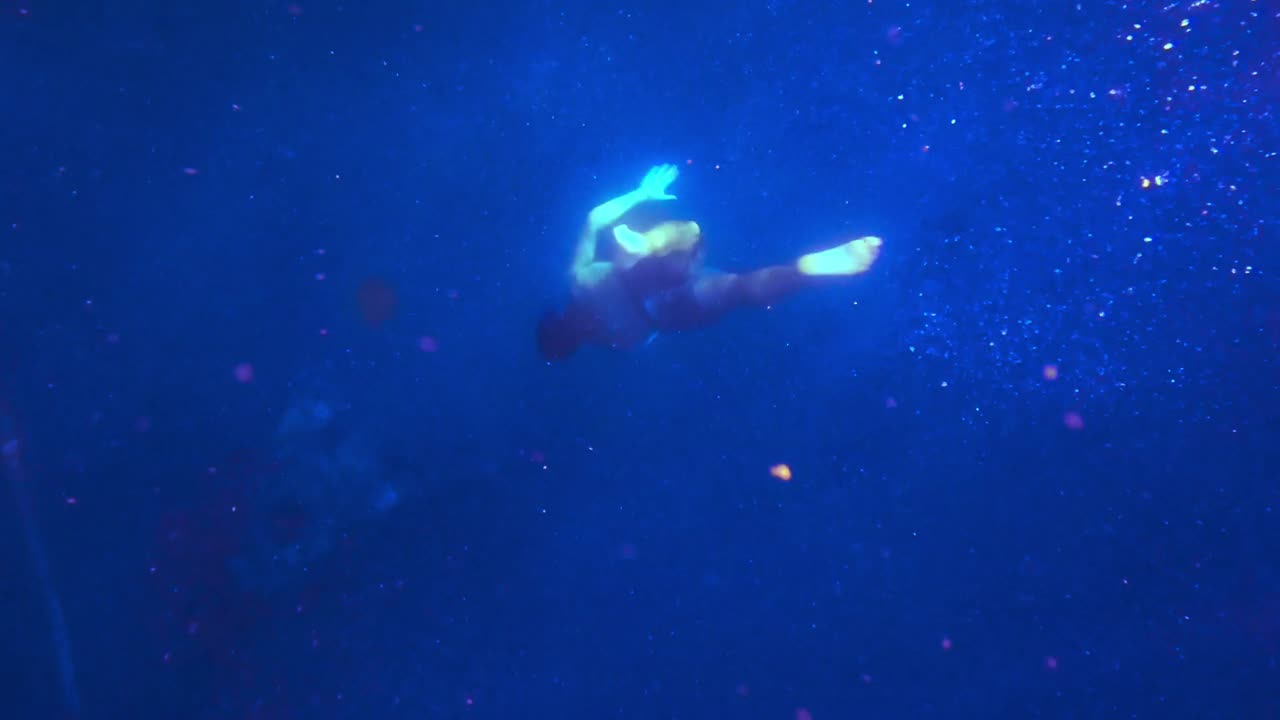 푸른 바다 속으로 점점 더 깊이 프리다이빙하는 남자