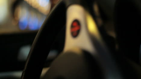 Car-steering-wheel.-Close-up-of-steering-wheel-turning.-Driving-in-city-at-night