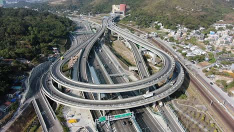 traffic on a massive highway interchange with multiple levels and loop shaped road in hong kong, aerial view