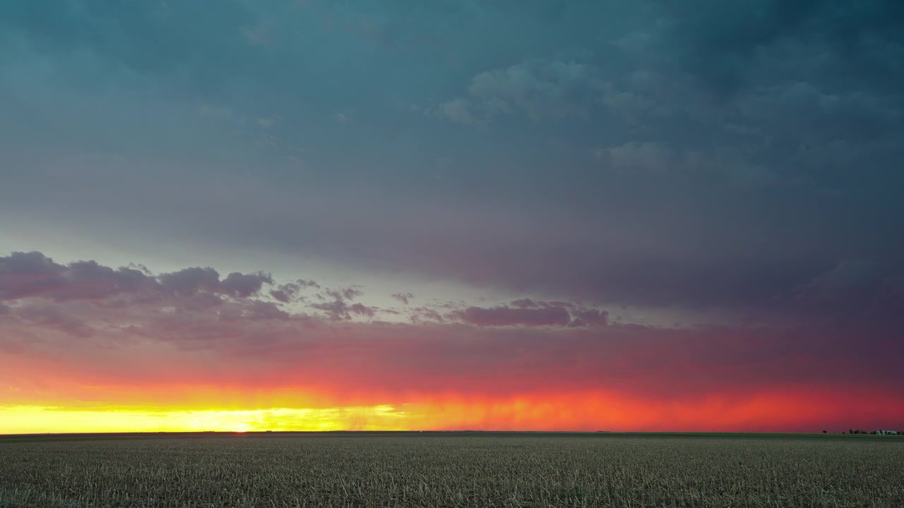 Orange sunset glow bursting through dark stormy clouds