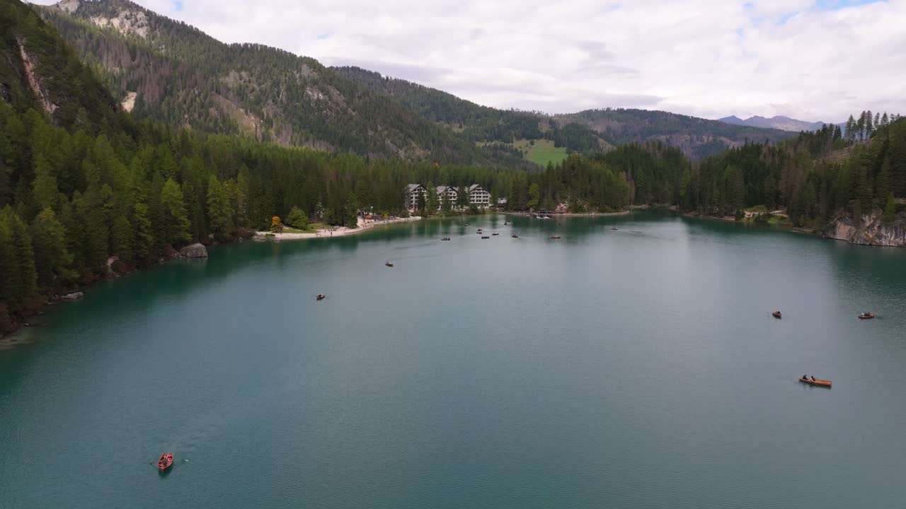 Aerial view of boats on Lake Braies surrounded by mountains and forest