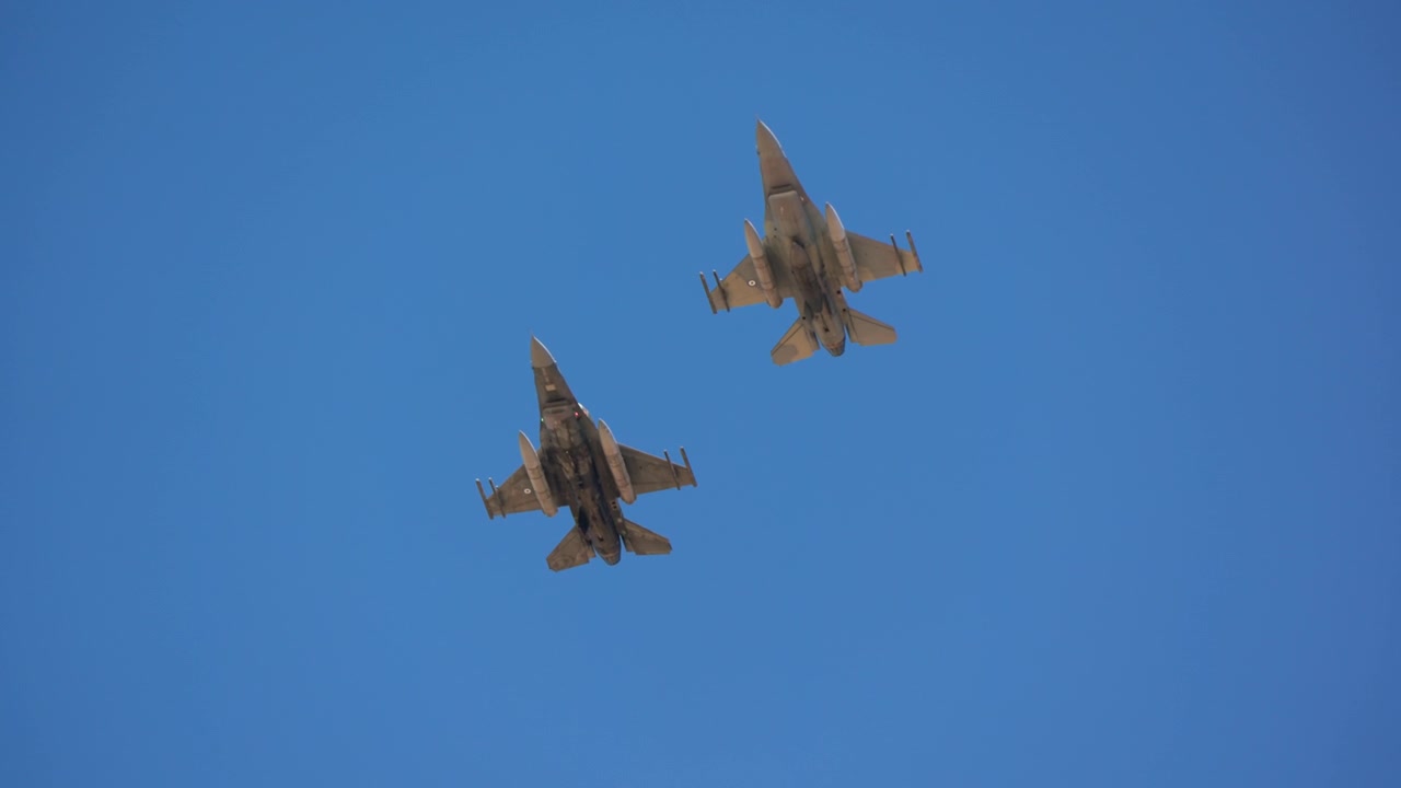 Two fighter jets flying in formation against blue sky