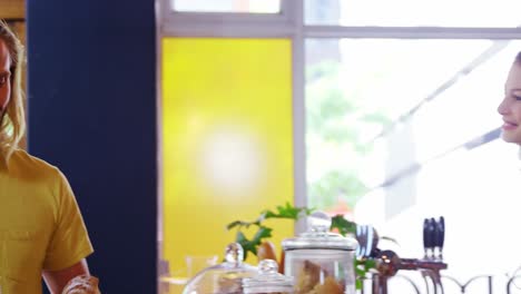 waitress serving coffee to male costumer at counter