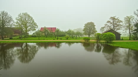 Timelapse-De-24-Horas-Sobre-Un-Lago-Tranquilo-Con-Edificios-De-Granja-En-Segundo-Plano