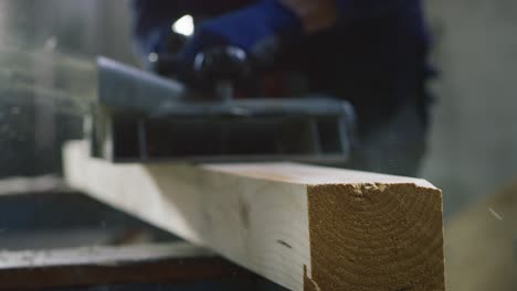 macro close up of professional carpenter working on woodworking machines in a workshop of wood factory.