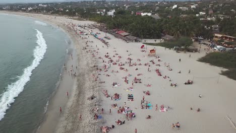 crowded-beach-on-the-pacific-ocean,-this-beach-ins-punta-Zicatela-known-world-wide-for-its-waves-and-beeing-known-as-the-mexican-pipeline