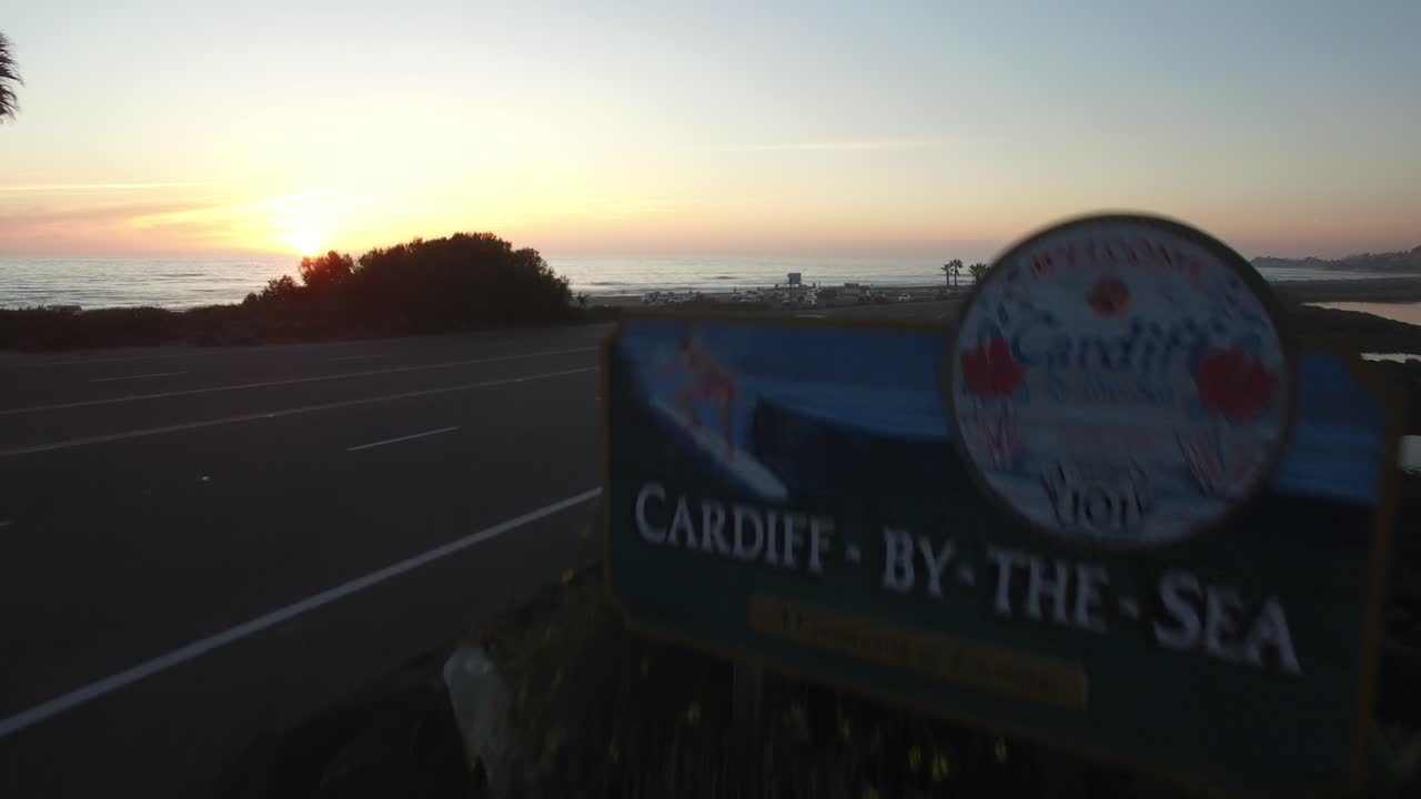 una antena sobre un cartel que da la bienvenida a los visitantes a cardiff junto al mar en san diego revela la playa al atardecer