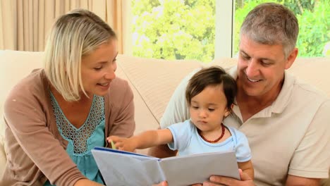 parents looking at book with baby