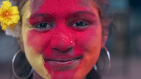 indian women close-up of face smeared with bright holi colors