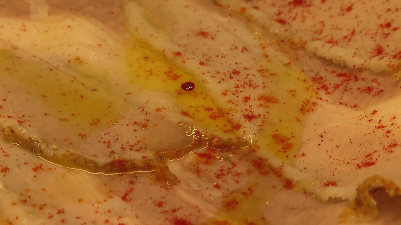 Closeup of cured pork slices with oil and paprika