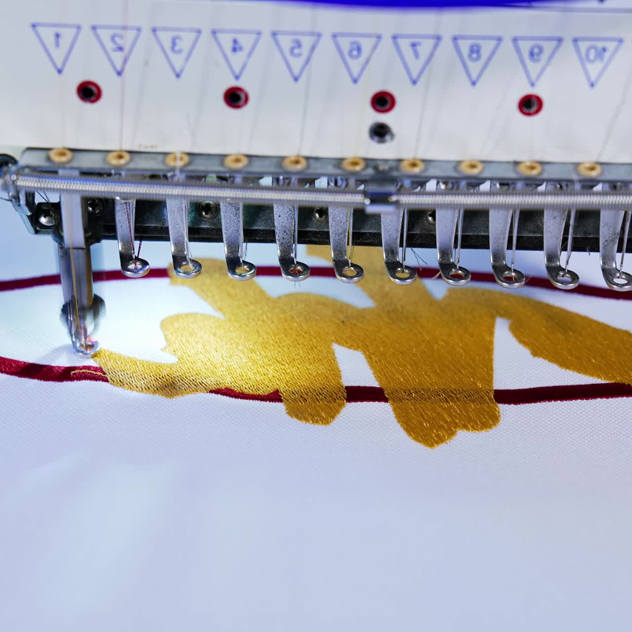 Embroidery machine in textile factory. Close up of computerized embroidery machines