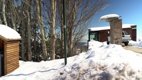 Vista-Panorámica-De-Una-Casa-Completamente-Llena-De-Nieve-Y-Un-Basurero-Con-Techo-Para-Protegerla-De-La-Acumulación-De-Nieve,-Farellones,-Chile