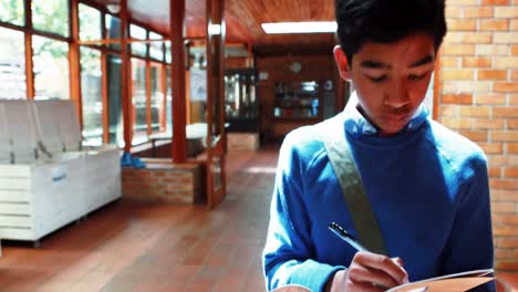 schoolboy witting while walking in corridor