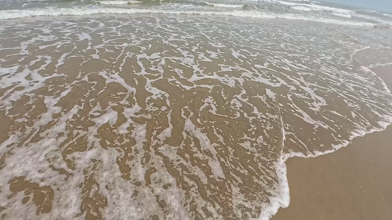 Waves Washing Ashore on a Sandy Beach