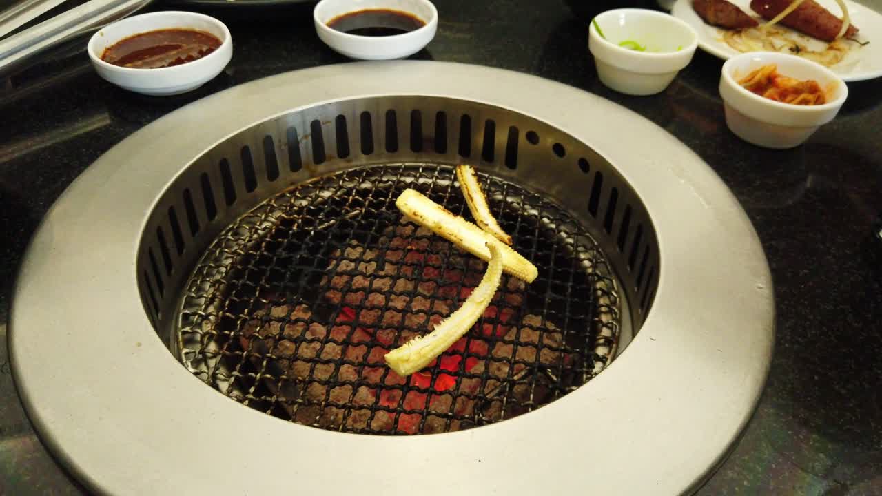 어린 옥수수는 쉽게 굽고 요리할 수 있도록 길이로 썰고 누군가가 먹을 때 숟가락과 포크가 움직입니다.