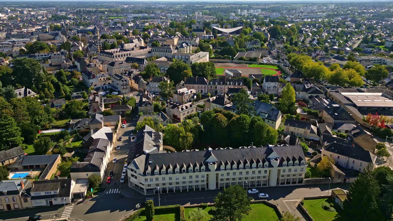 Drone fly over Laval town cityscape with ordinary and historic buildings in sunny day, Mayenne, France