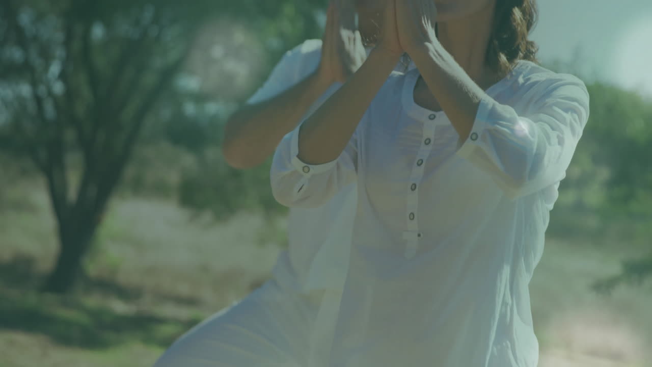 Animation of light spots over caucasian couple practicing yoga