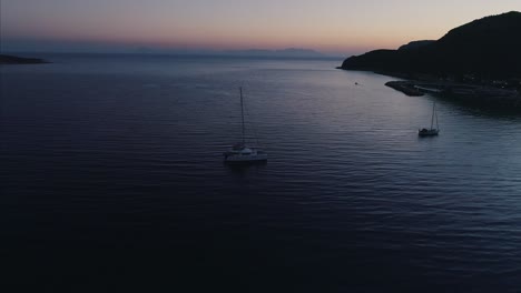 boats floating near the shore at sunset