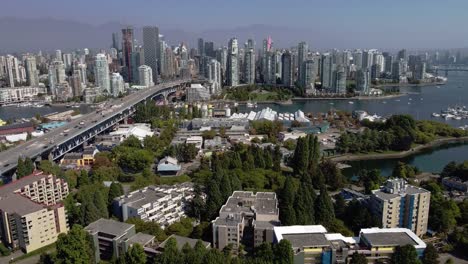 aerial panaramic fly over uptown vancouver seaside waterfront homes of false creek granville island yaletown 4 way river bridge to downtown on a sunny afternoon with horizon foggy mountains 2-4