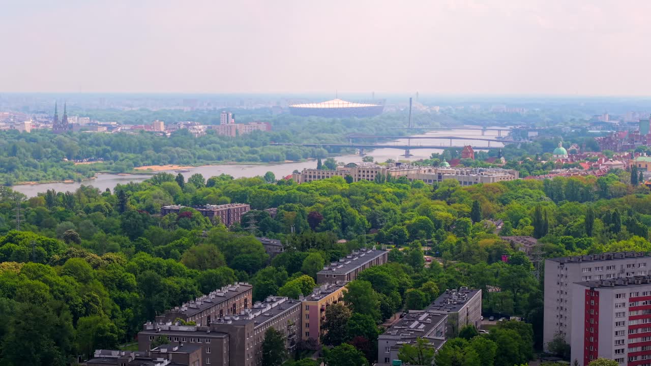 Aerial orbit of Zoliborz with distant view of stadium and Vistula bridges in spring along the water