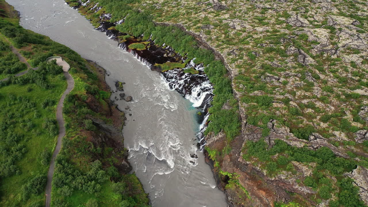 cascada de agua que fluye del exuberante paisaje volcánico