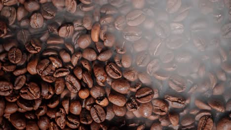 close up of seeds of coffee. fragrant coffee beans are roasted smoke comes from coffee beans.