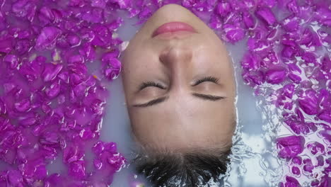 woman enjoying a relaxing milk bath with rose petals
