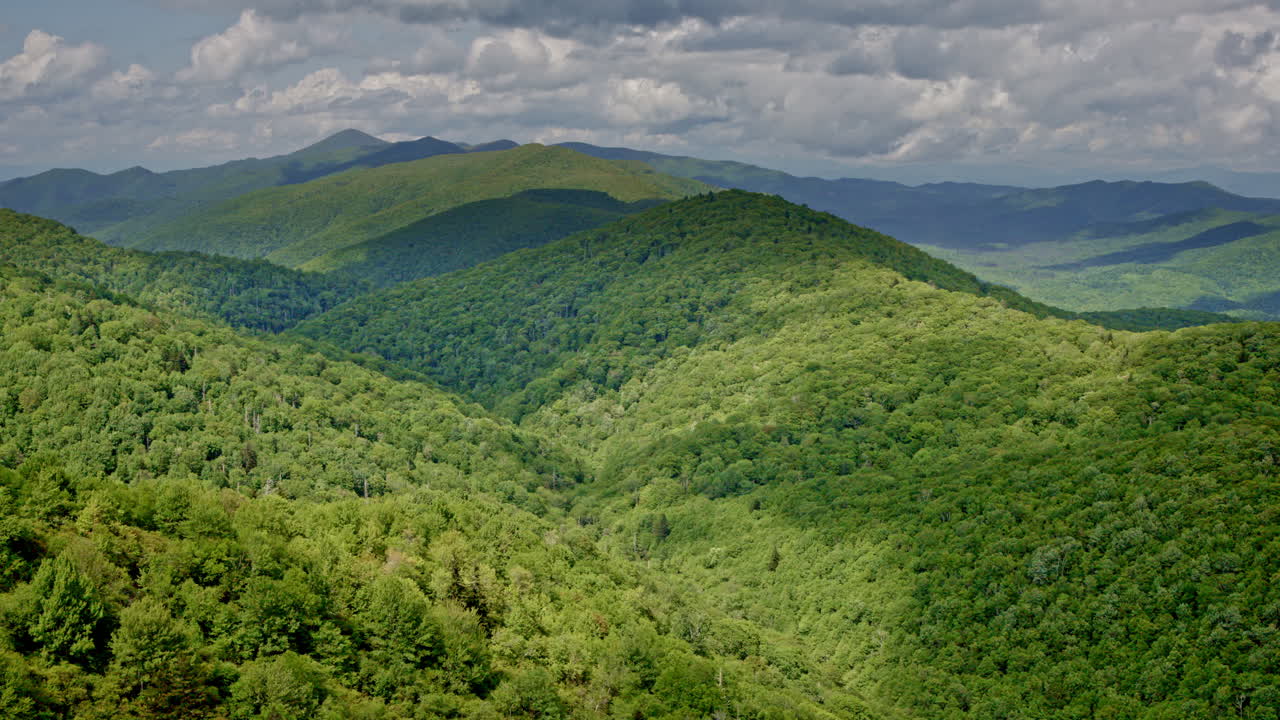 Atmospheric drone shot soaring across a misty, rain-soaked Smoky Mountain landscape
