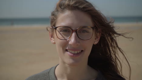 un primer plano de una joven sonriente con gafas.