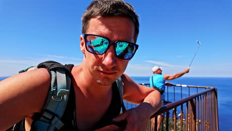 man with sunglasses enjoying a scenic ocean view