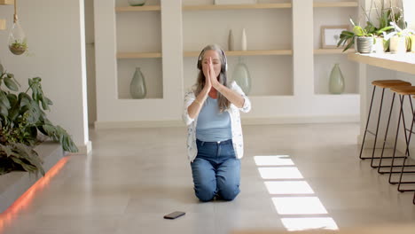 caucasian woman with grey hair practicing yoga at home