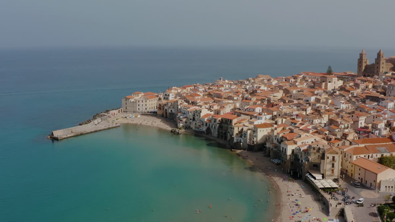 aerial tilt up drone shot della spiaggia di cefalu. piccola città storica italiana in sicilia paesaggio sul mare.