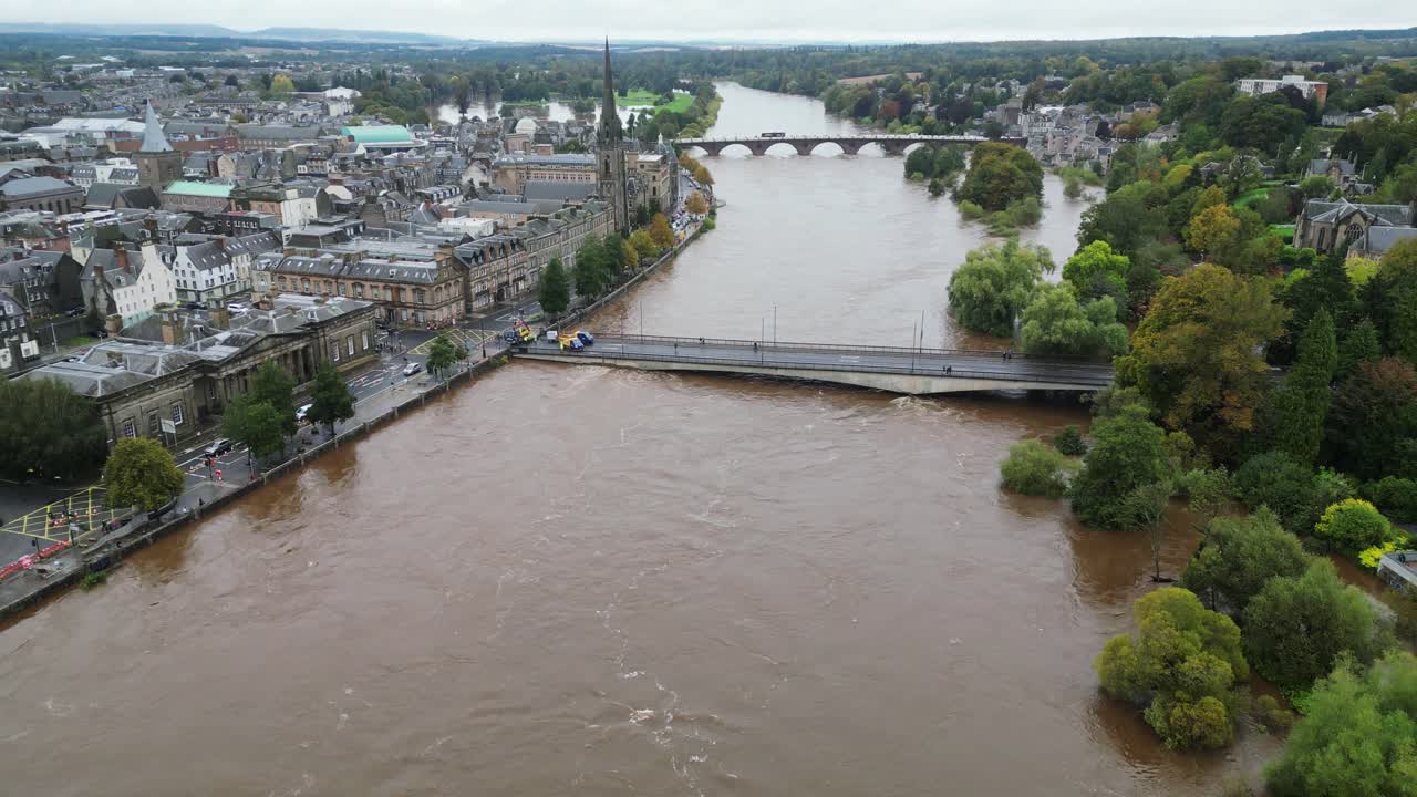Aerial footage showing The Queen's Bridge in Perth being closed to traffic during floods on River Tay- Camera tilting down